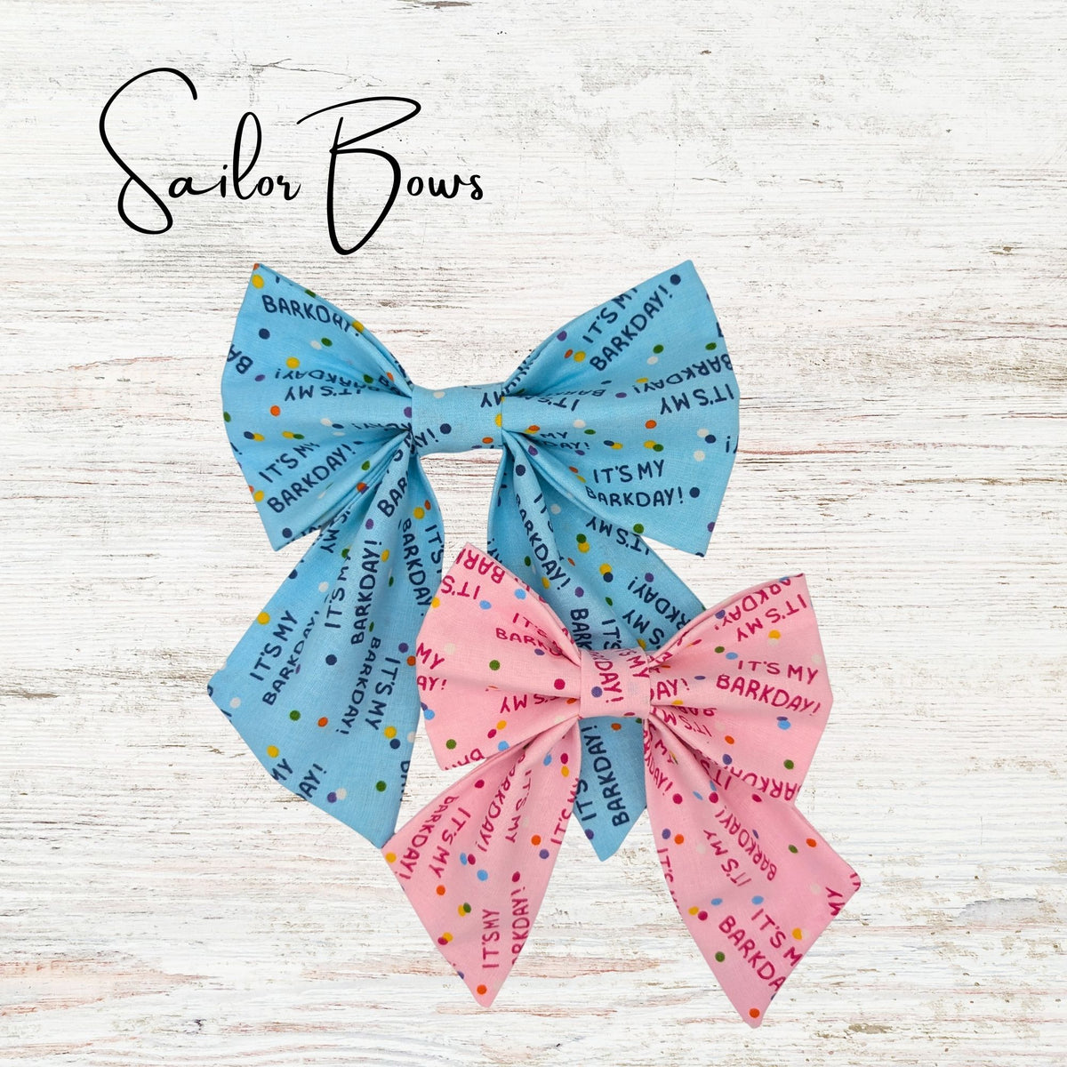 Pet sailor bows on a light wooden background. The bowties are pink and blue and have text saying "It's my barkday"