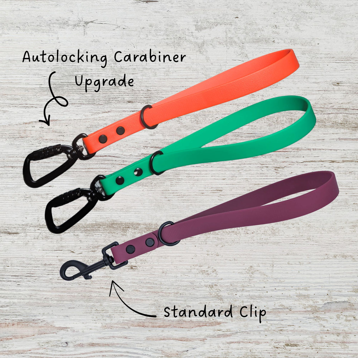 Three dog leash traffic handles in orange, green, and merlot. All are made with genuine BioThane. Two have the autolocking carabiner upgrade and the other has the standard clip.