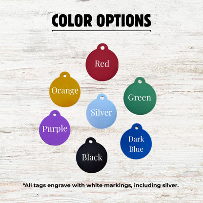 Color options for engraved tags displayed on a wooden surface.
