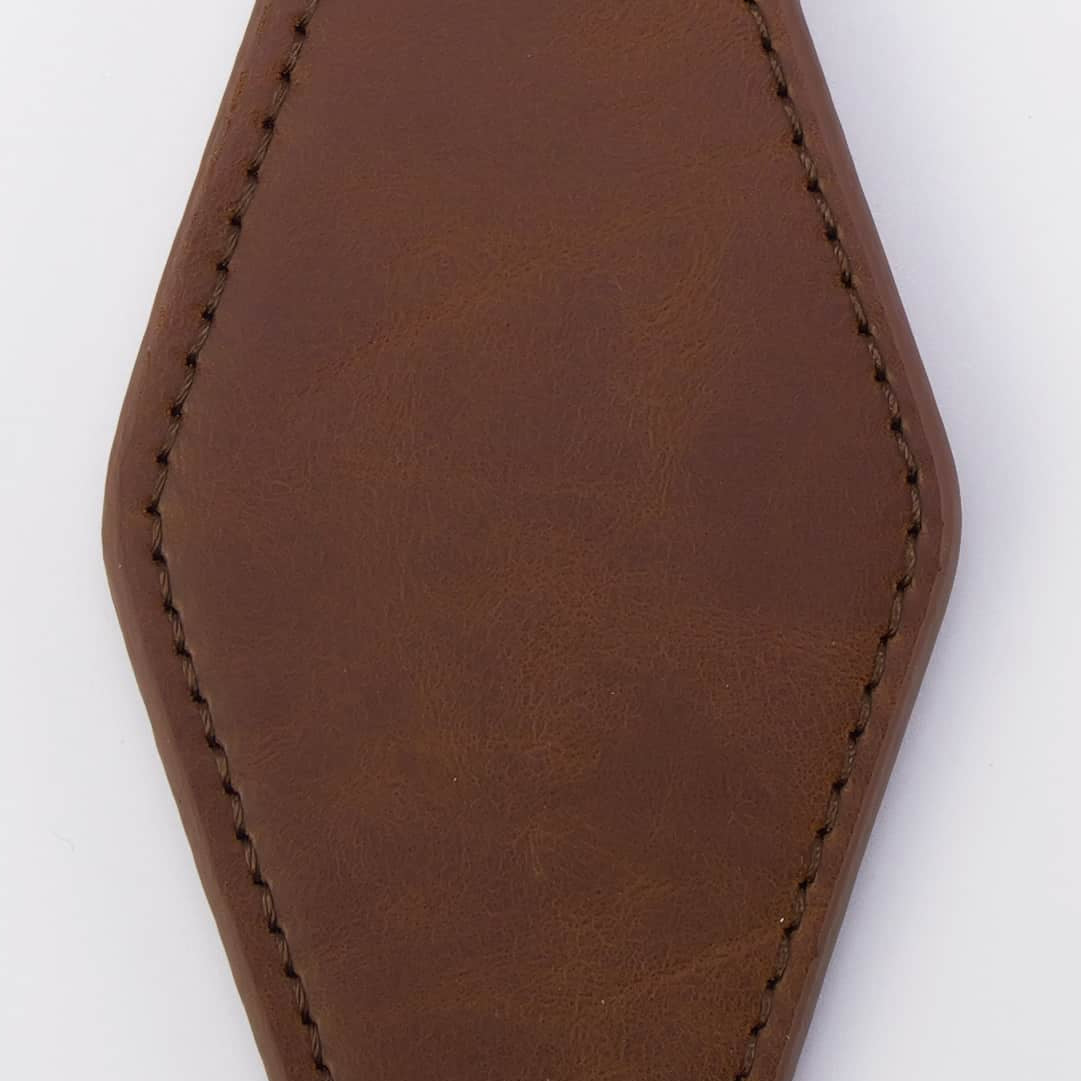 A blank brown leather keychain tag with a hexagonal shape, featuring stitched edges and a black metal clasp attached to a split keyring on a white background.