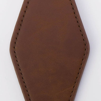 A blank brown leather keychain tag with a hexagonal shape, featuring stitched edges and a black metal clasp attached to a split keyring on a white background.