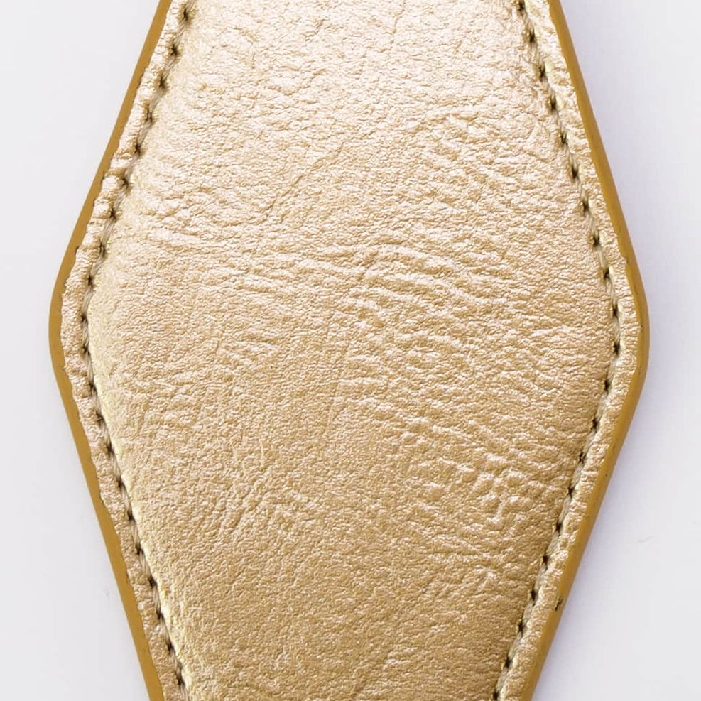 A gold-colored faux leather keychain with a stitched geometric shape, attached to a black metal split ring and key ring, shown on a plain white background.