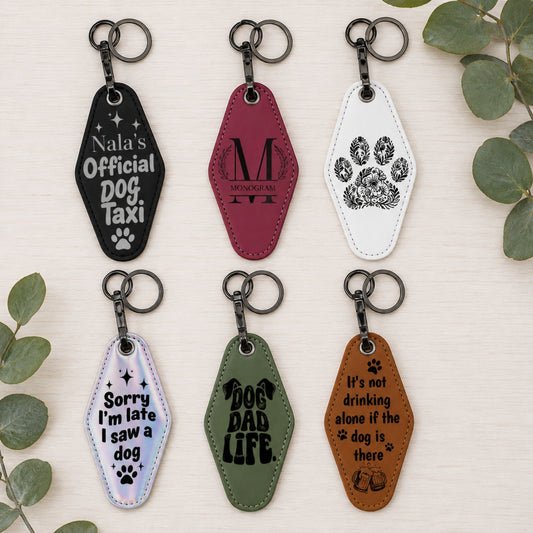 A collage showing multiple retro-style motel keychains in assorted colors, with one keychain engraved with 'LESS PEOPLE MORE DOGS' on a wooden board and another shown being held in a hand. The text 'Retro Style Motel Keychain' appears across the center.