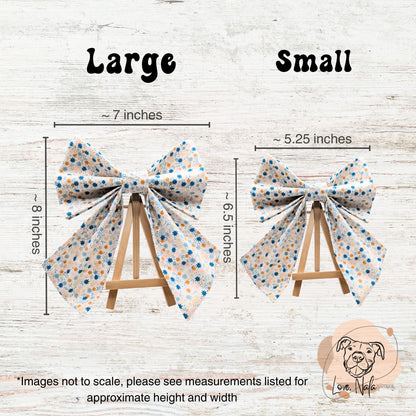 Two floral print pet sailor style bows with measurements on a wooden background and a love nala boutique logo