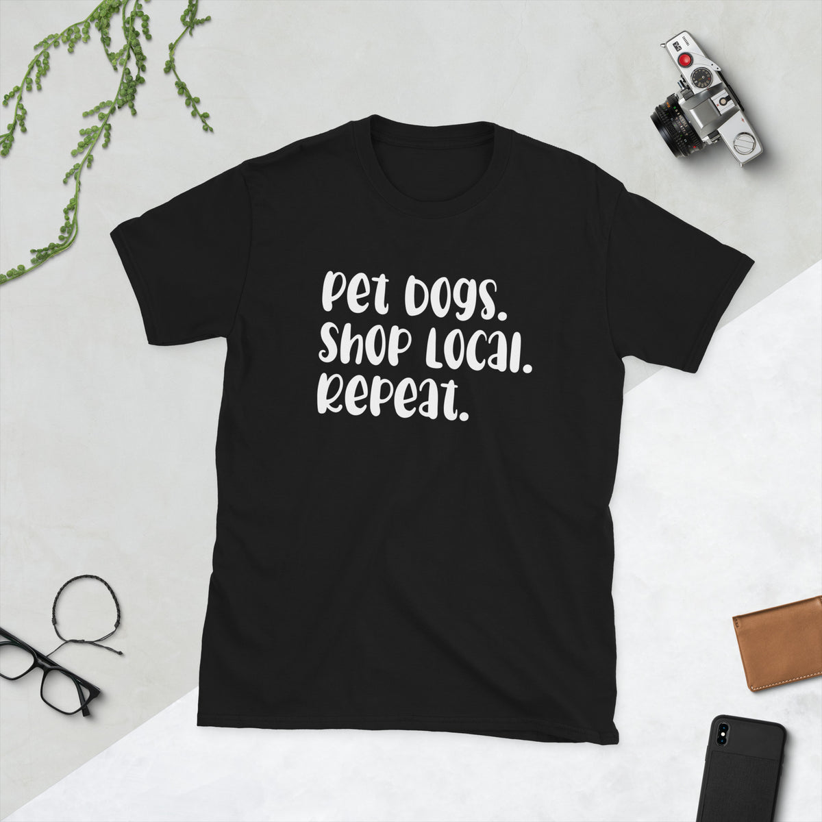 Product mockup of a t-shirt that says 'pet dogs shop local repeat'. the shirt is black