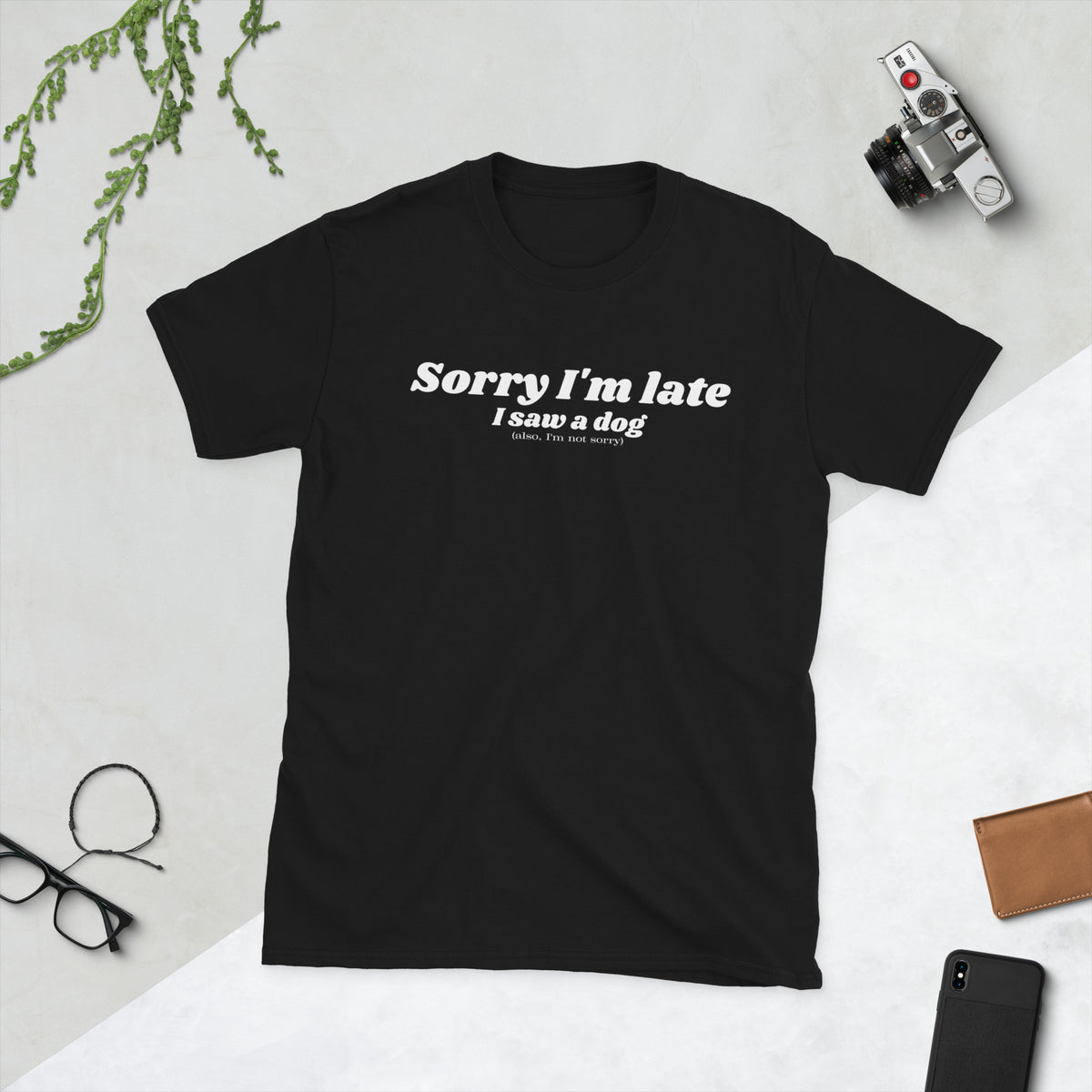 Product mockup of a t-shirt that says 'sorry I'm late I saw a dog. also I'm not sorry'. the shirt is black