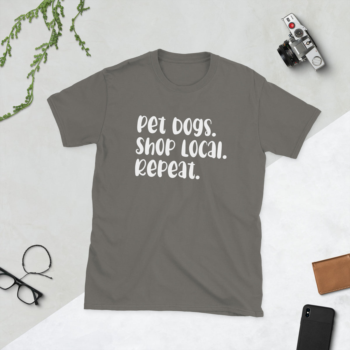 Product mockup of a t-shirt that says 'pet dogs shop local repeat'. the shirt is grey