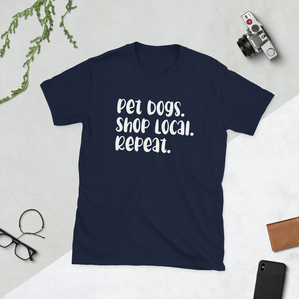 Product mockup of a t-shirt that says 'pet dogs shop local repeat'. the shirt is blue
