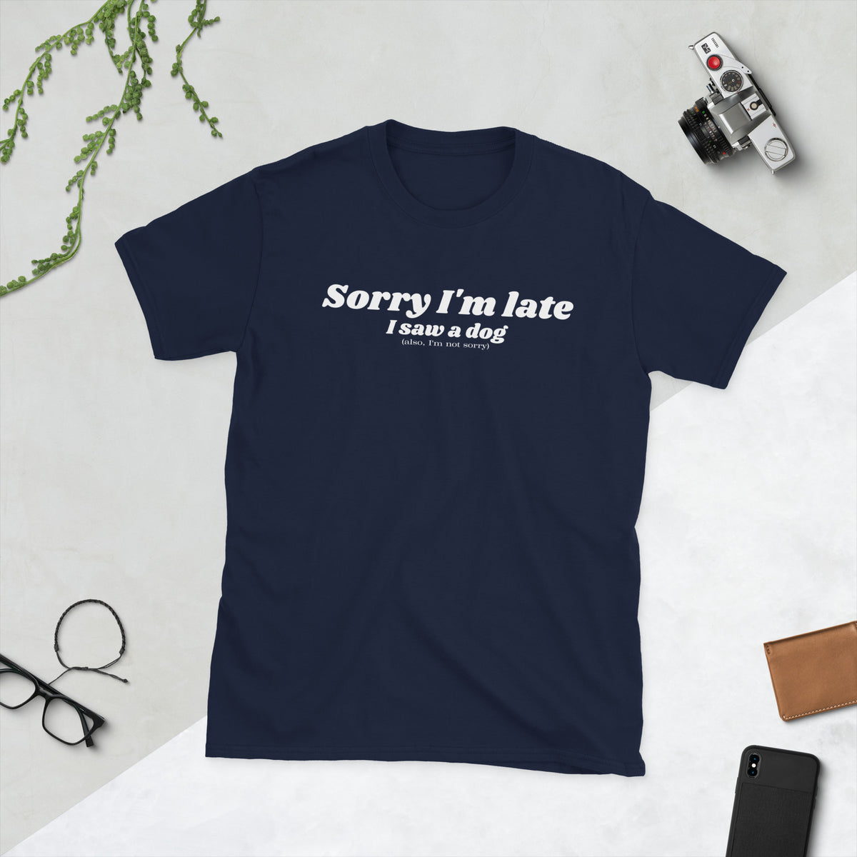 Product mockup of a t-shirt that says 'sorry I'm late I saw a dog. also I'm not sorry'. the shirt is navy blue