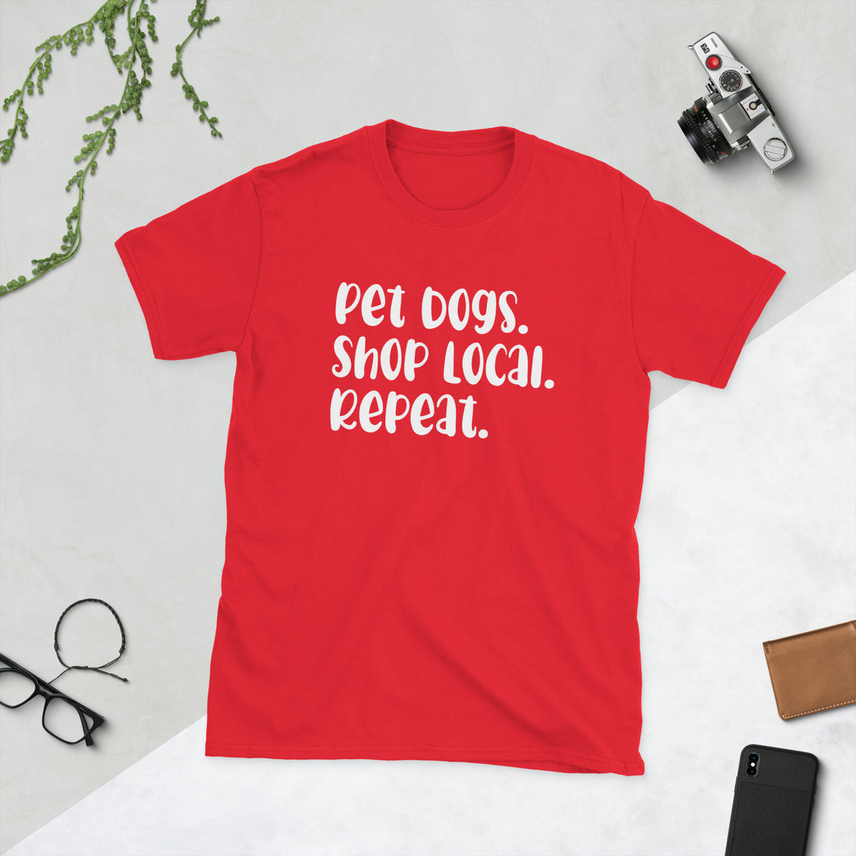 Product mockup of a t-shirt that says 'pet dogs shop local repeat'. the shirt is red
