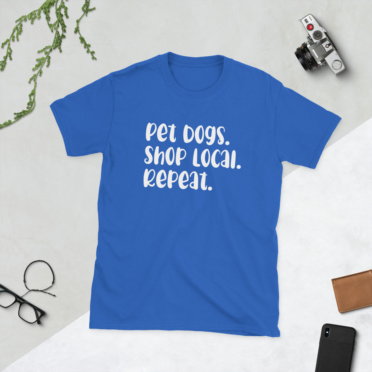 Product mockup of a t-shirt that says 'pet dogs shop local repeat'. the shirt is bright blue